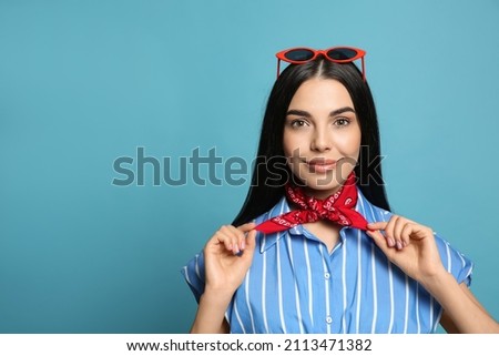 Fashionable young woman in stylish outfit with bandana on light blue background, space for text Royalty-Free Stock Photo #2113471382
