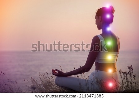 Woman meditating near sea. Scheme of seven chakras, illustration Royalty-Free Stock Photo #2113471385