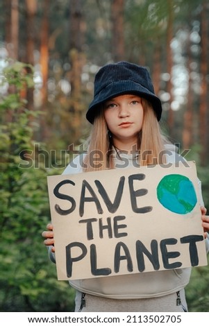 child girl activist with save the planet poster in forest park. preteen kid volunteer fight against pollution, Global Warming, recycle garbage. Ecology environmental problem no war,peace in world