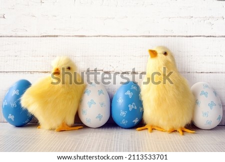 Chicken with Easter eggs on wooden background
