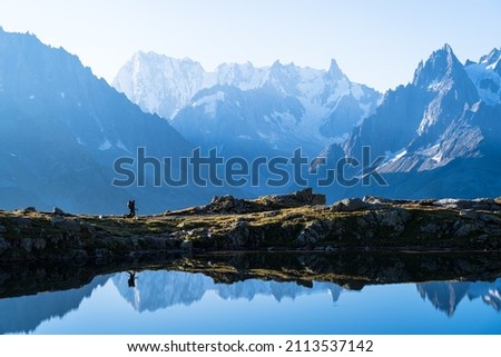 Woman hiking at Lac des Cheserys, with a view at the beautufil mountains of Chamonix. Royalty-Free Stock Photo #2113537142