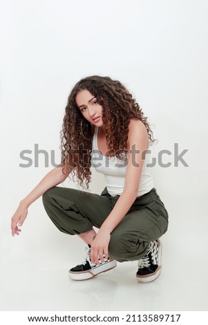 pretty hispanic girl with beautiful long curly hair and urban look on white background