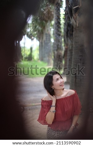 Charming beautiful girl with short hair in the sugar palm garden on weekends. woman and nature