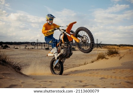 Skilled moto rider making stunt on motorbike Royalty-Free Stock Photo #2113600079