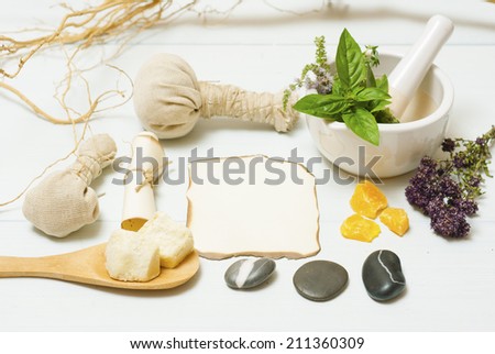 herbs, spices and massage pouches on white wooden table
