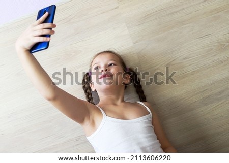 girl child with pigtails talking on the phone, getting homework on a cellular connection, during isolation and a pandemic, a convenient means of communication