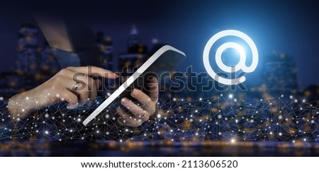 Business email concept. Hand touch white tablet with digital hologram Email sign on city dark blurred background. Email marketing concept. Sending newsletter.