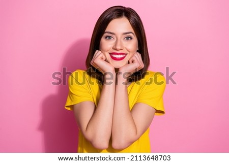 Portrait of attractive cute girlish brown-haired cheerful girl wear yellow tshirt isolated over pink pastel color background