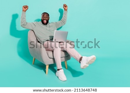 Full length body size view of handsome trendy cheery lucky guy using laptop rejoicing isolated over vivid teal turquoise color background Royalty-Free Stock Photo #2113648748