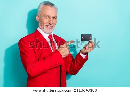 Photo of charming retired man wear red three piece suit pointing bank card isolated turquoise color background