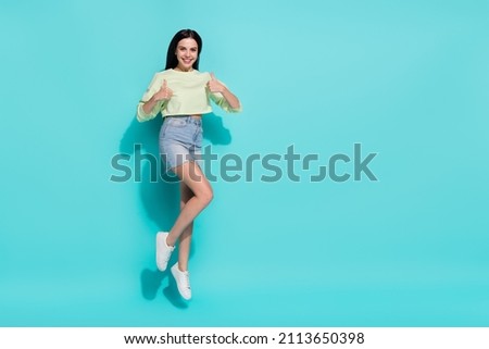 Full size photo of lovely lady jump up empty space make thumb up symbol approve discounts isolated cyan color background