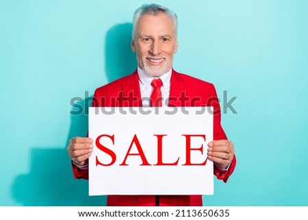 Photo of cheerful retired man wear red three piece suit holding sale poster isolated turquoise color background