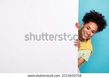 Photo of young african excited girl hold hands advert announcement poster isolated over blue color background