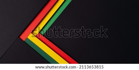 Black History Month color background. African American history month celebration. Abstract red, yellow, green color flag on black paper background Royalty-Free Stock Photo #2113653815