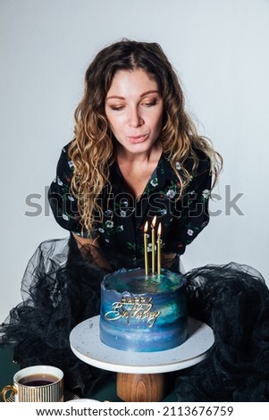a woman blows out the candles of a delicious birthday cake