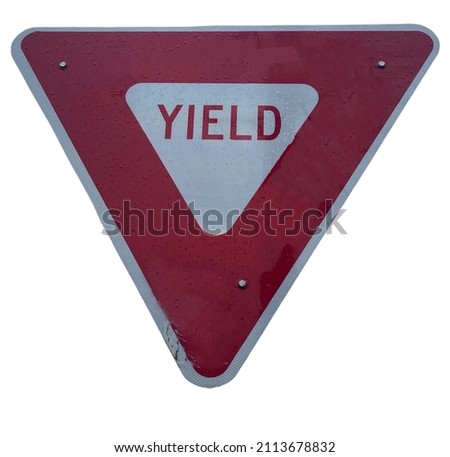 A triangular red and white yield sign close up with with a white background