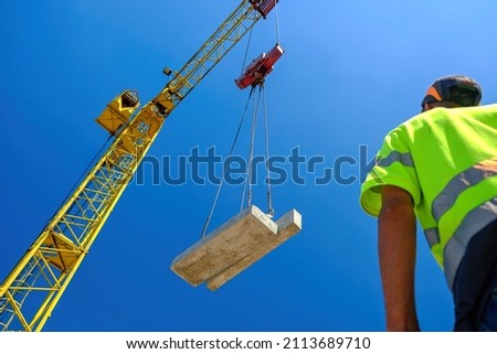 construction worker with crane. Hook cargo crane on the sky background. crane on a construction site Royalty-Free Stock Photo #2113689710