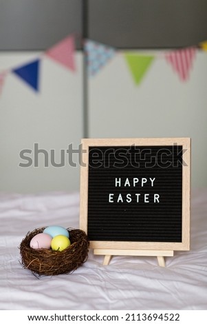 Stylish background with colorful easter eggs pastel colors in basket on bed. Easter celebrating at home during Coronavirus covid-19 pandemic