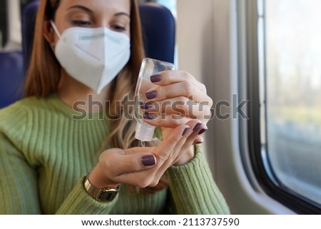 Business woman with medical face mask using alcohol gel sanitizer hands on public transport. Antiseptic, hygiene and health care concept. Focus on hand with alcohol gel bottle. Royalty-Free Stock Photo #2113737590
