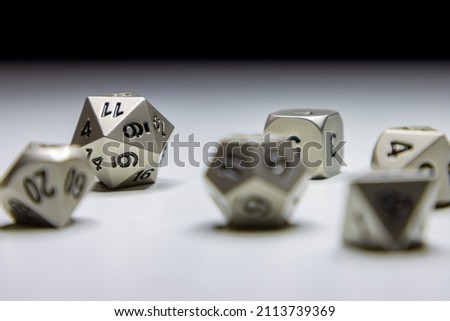 Close up photo of silver metal fantasy role playing strategy game dice on white surface