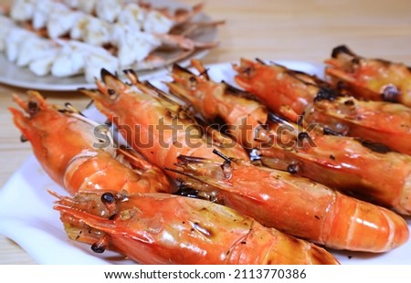 Closeup of Delectable Flaming Grilled River Prawns on a White Plate Royalty-Free Stock Photo #2113770386