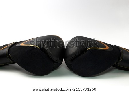 Close up a pair of black leather gloves lie side by side on white background