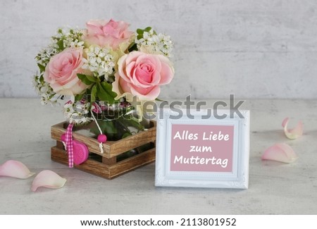 Frame with the text Happy Mother's Day, Translated schönen muttertag, with bouquet of pink roses.