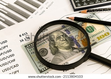 Dollars and money estimate through a magnifying glass close-up. Finance and business. Financial calculator