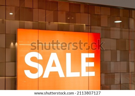 Sale sign at the entrance to clothing store - large red panels with white words. Seasonal discount offer in store. Discounts and black friday concept.big reductions