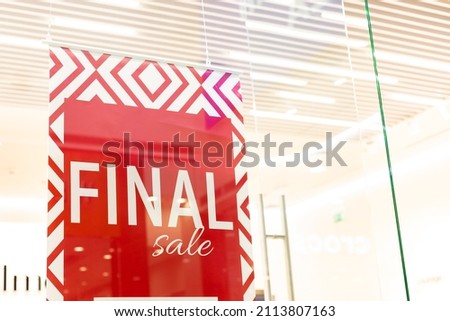 Sale sign at the entrance to clothing store - large red panels with white words. Seasonal discount offer in store. Discounts and black friday concept.big reductions