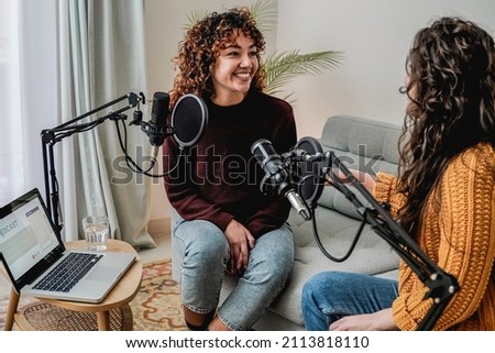 Female host recording radio podcast interview with guest at home office - Focus on latin woman face