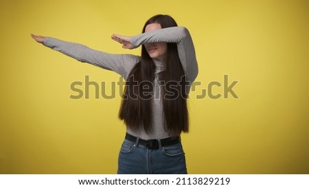woman in gray turtleneck makes hype movement dab with her hands and covers her face. When you won or did everything right. Yes, I am very cool.