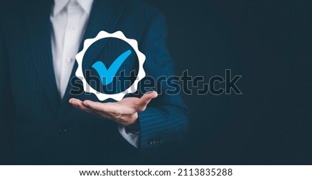 Quality assurance of business services, Businessman Hand shows the sign of the top service Quality assurance in Black background , Guarantee, Standards, ISO certification and standardization concept. Royalty-Free Stock Photo #2113835288