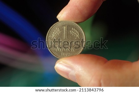 Old Deutsche Mark Coin in the male hand background