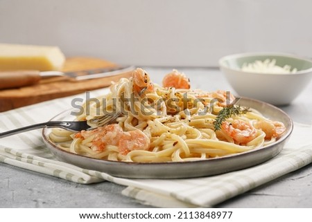 Flat plate with pasta spaghetti with heavy cream and roasted shrimps with garlic sauce and parmesan cheese on concrete surface Royalty-Free Stock Photo #2113848977