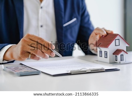 The real estate agent describes the home and materials and the client is discussing a home purchase contract, insurance or real estate loan.