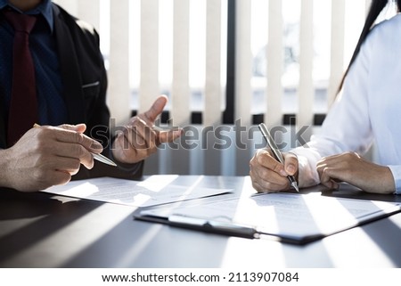 The home insurance salesman and the customer are signing an insurance agreement with their insurance company, accepting the terms and benefits. Home and real estate insurance concept.
