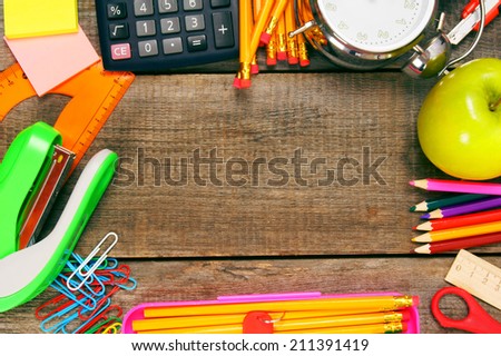 Back to school. School tools around. Vertically. A wooden background.