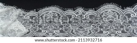White lace on a black background. Template for wedding invitation and greeting card with lace fabric background. Panoramic shot of a photo