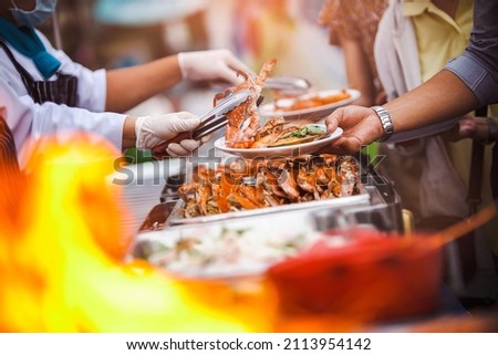 Chef Cater cooking main dish crab and shrimps BBQ serving for guest in wedding ceremony party or outdoor seafood gardens. Buffet or fine dining event. Food Festival cooking catering celebrates ideas. Royalty-Free Stock Photo #2113954142