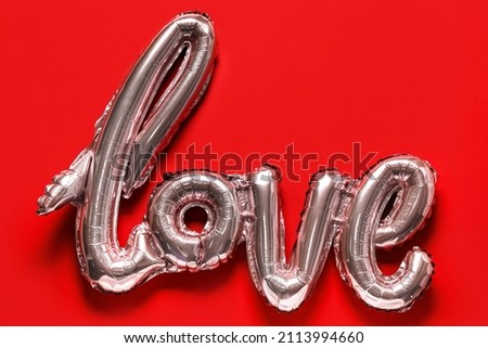 Balloon in shape of word LOVE on red background. Valentine's Day celebration