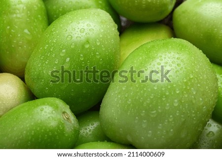 Fresh green tomatoes as background, closeup