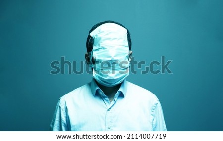 whole face covered with mask. exaggerated protection. business man wrapped up him face with medical mask.  Royalty-Free Stock Photo #2114007719