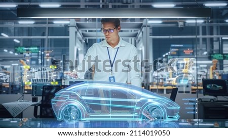 Green Energy Car Design: Automotive Engineer Using Augmented Reality Hologram to Construct 3D Model of High-Tech Electric Vehicle Optimizing Battery Efficiency. Automated Robot Arm Manufacturing Royalty-Free Stock Photo #2114019050