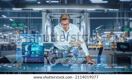 High-Tech Industry: Engineer Designing 3D Engine, Using Augmented Reality Hologram Table to Analyse Prototype Model. Turbine for Green Energy Electricity Production. Automated Robot Arm Manufacturing Royalty-Free Stock Photo #2114019077