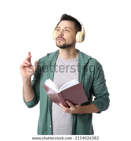 Man with headphones and book on white background