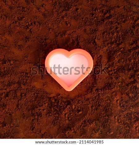 Vibrant heart in the middle of brown earthy or coffee background. Love concept design. Valentine spring flat lay
