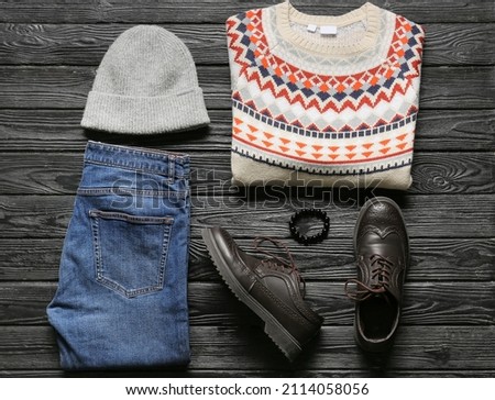 Stylish male clothes and shoes on dark wooden background