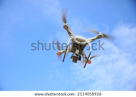 White drone with camera flying in summer mountain top