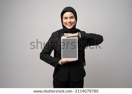 Portrait of young beautiful muslim businesswoman  is holding tablet over white background studio